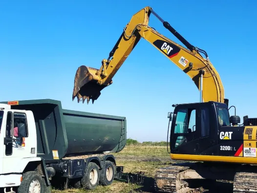 Excavadora CAT 320 cargando un camión volcador, alquiler de maquinaria en Gualeguaychú